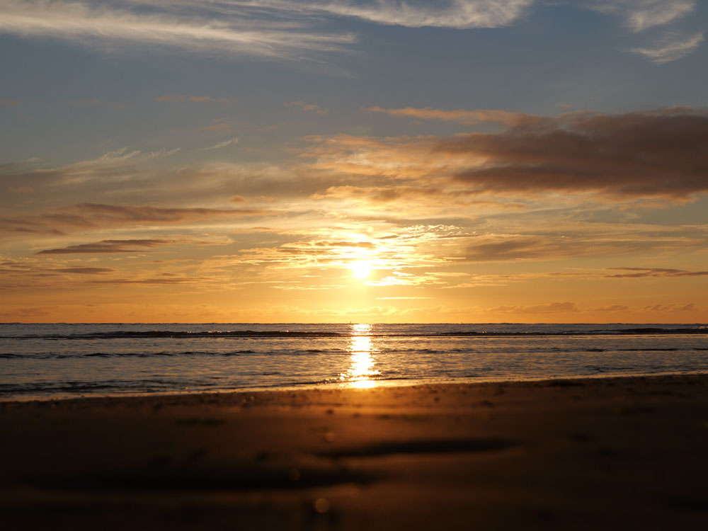 Sonnenuntergang am Meer mit Sandstrand